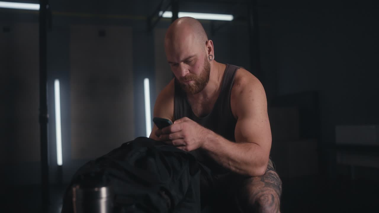 Uomo che usa lo smartphone in palestra