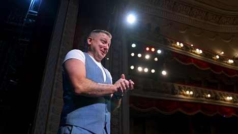 comedian on stage. middle-aged speaker standing on stage and talking to someone. smiling actor rehearses on scene.