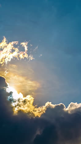 bright sunlight behind moving dense clouds in blue sky. timelapse