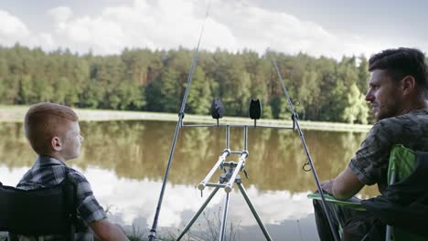 zoom out video of father teaching son how to fish