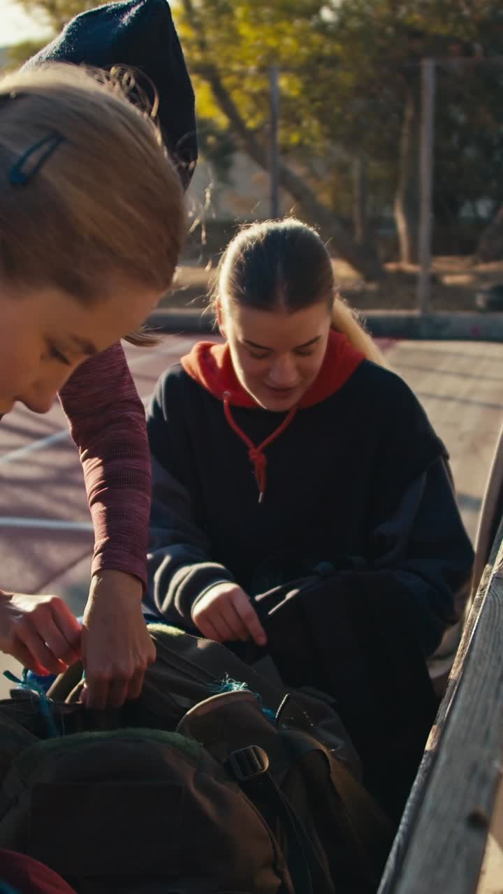 Young women packing backpacks outside
