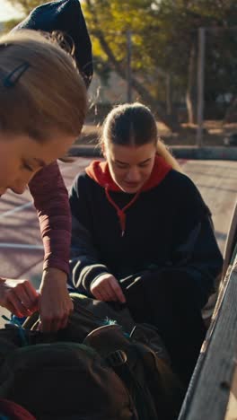 young women packing backpacks outside