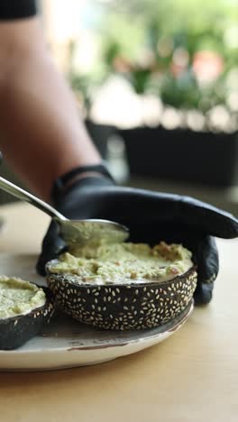 preparando un sándwich de tostadas de aguacate en pan negro