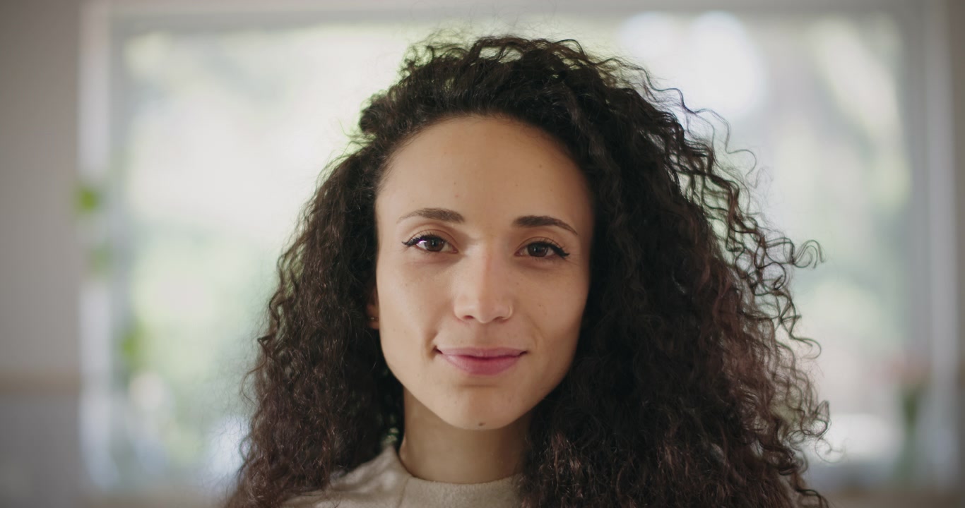 Una donna con i capelli ricci che sorride