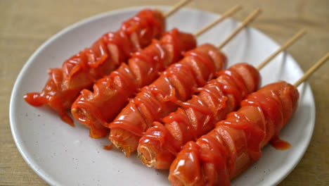 fried-sausage-skewer-on-white-plate