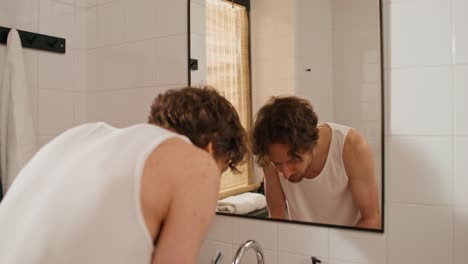 man washing his face in the bathroom