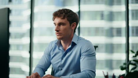 Portrait-depressed-businessman-sitting-modern-office.-Man-working-at-pc-closeup.