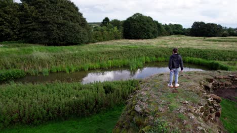 aerial video footage of a young boy looking out on the the remains of bolingbroke castle