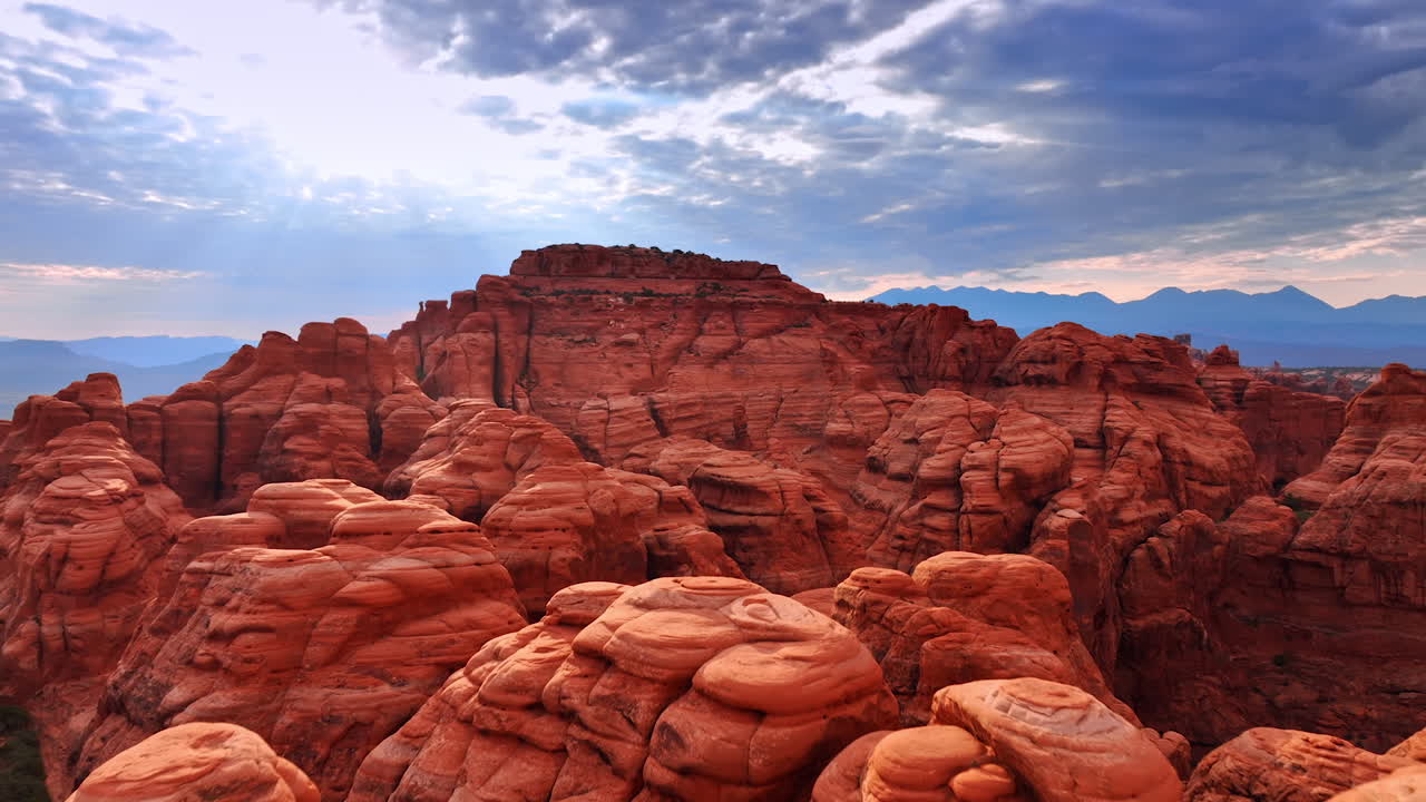 Columnas de roca rojas redondeadas y caprichosas en un grupo grande. Vídeo aéreo acercándose a los cañones del Parque Nacional Arches, Utah, EE. UU.
