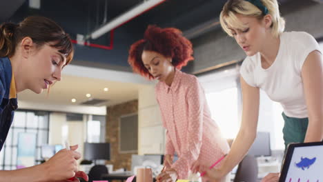 collaborating on project, diverse women discussing ideas in modern office workspace