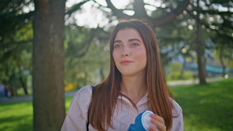 chica sana hidratando botella de agua en el parque soleado. mujer de primer plano disfrutando de la naturaleza