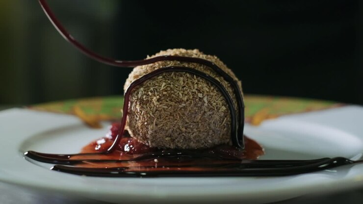 Una sfera di cioccolato al dessert ricoperta di scaglie