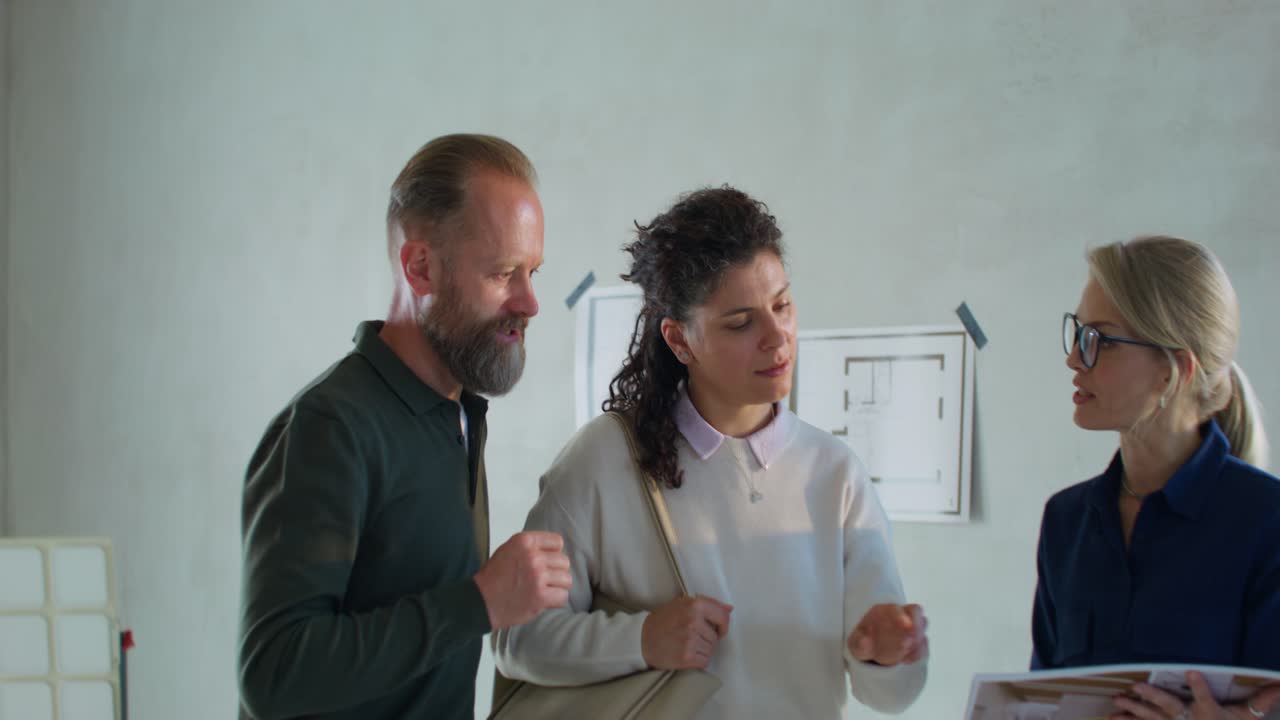 pareja mirando los planos de la casa con un agente de bienes raíces