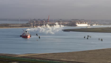 Anchored-ship-funnel-smoke-polluting-dutch-industrial-Mississippi-port---aerial