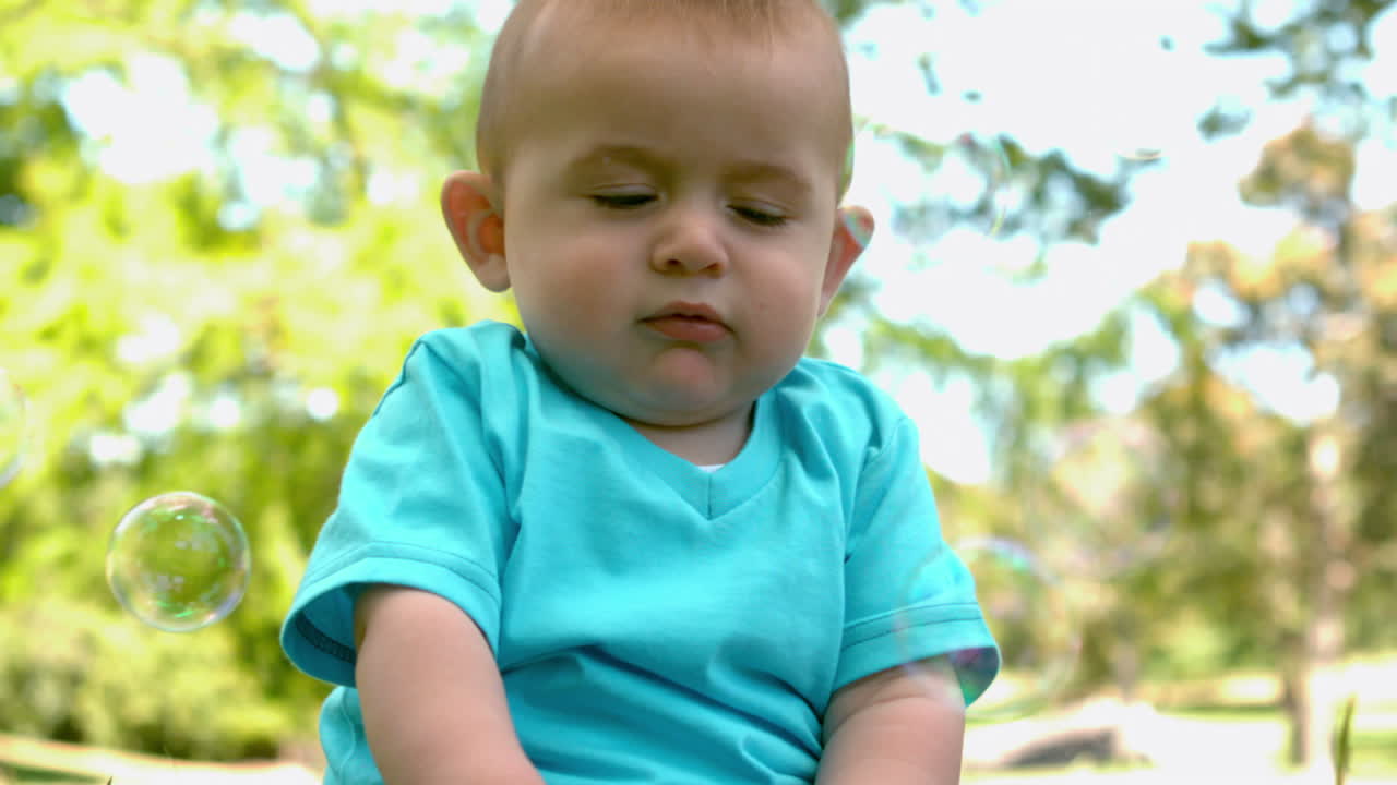 um bebé bonito sentado na relva.