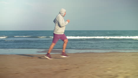 Hombre-Mayor-Corriendo-A-Lo-Largo-De-La-Playa