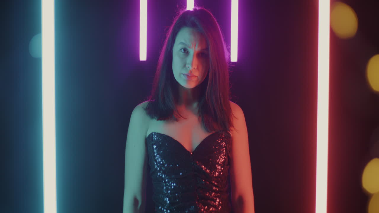 Woman in a sparkly sequin dress under vibrant neon lights