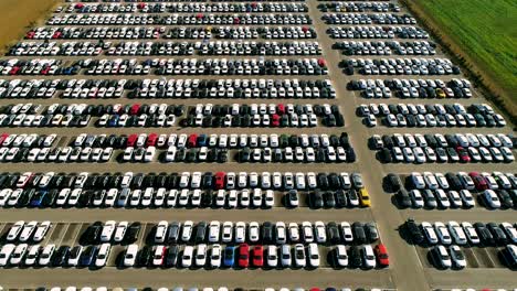 aerial footage of finished cars ready to be shipped on huge distribution center