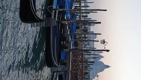 docked gondolas at sunset with santa maria della salute church in background, venice in italy