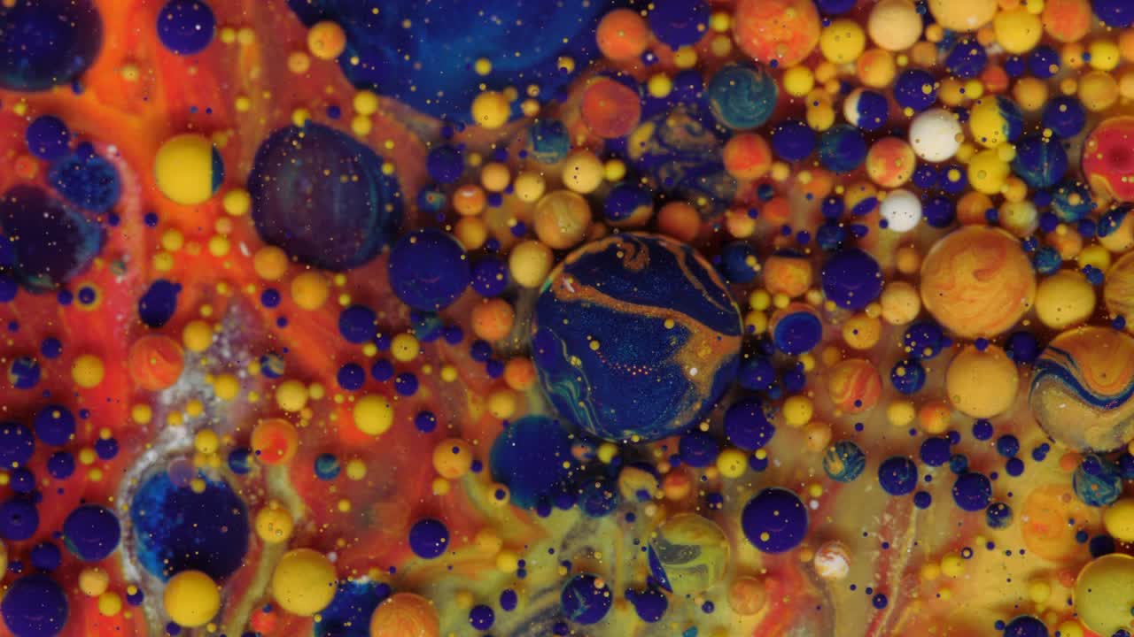 burbujas rojas, azules y amarillo-doradas sobre un fondo rojo.