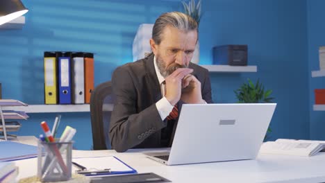 un hombre de negocios estresado y nervioso mirando la computadora portátil con atención y seriedad.