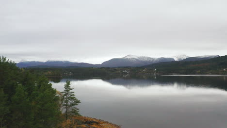 Aerial-View-Of-Calm-Lake-With-Mountain-Views-On-A-Cloudy-Day-In-Norway