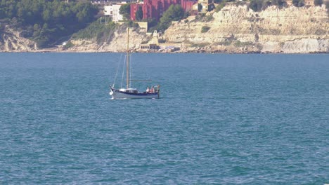 Small-sailing-yacht-on-blue-sea,-mediterranean-coast-of-Spain