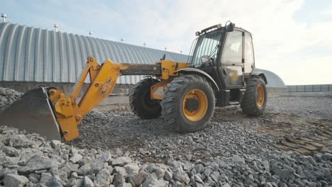 tractor mueve escombros al camión. excavadora-cargador rastrilla escombros de la pila en el sitio de construcción y carga el camión de descarga. sitio de limpieza