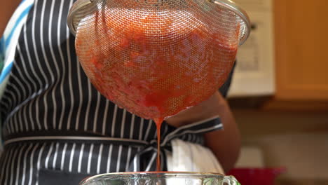 African-American-Woman-Mashes-Tomatoes-in-Strainer-into-Bowl,-Close-Up