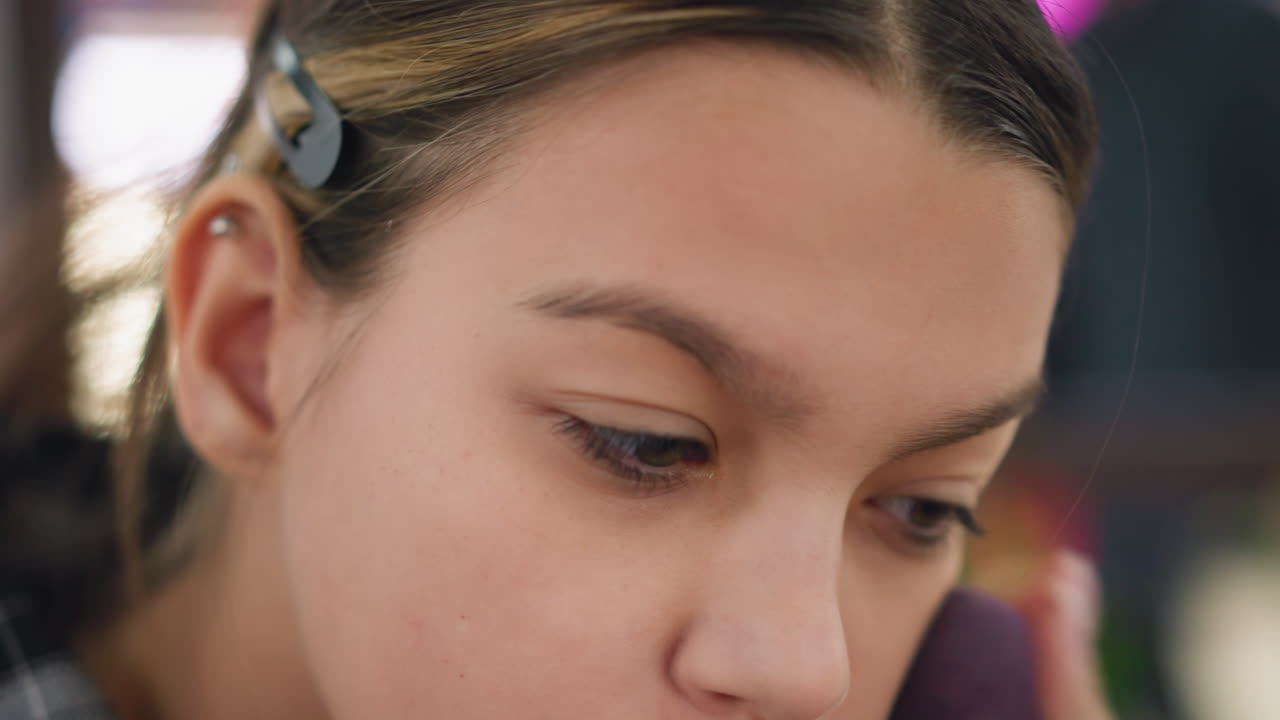 primer plano de una mujer joven mezclando cuidadosamente el maquillaje en toda la cara usando una esponja de belleza, la aplicación suave mejora la complexión, la iluminación suave y el fondo borroso crean un aspecto de belleza profesional