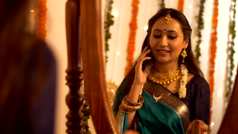 well-dressed south-indian woman inviting her friends to celebrate diwali festival over a phone call