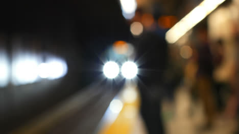 Blurred-commuters-waiting-for-train-on-subway-platform-4k