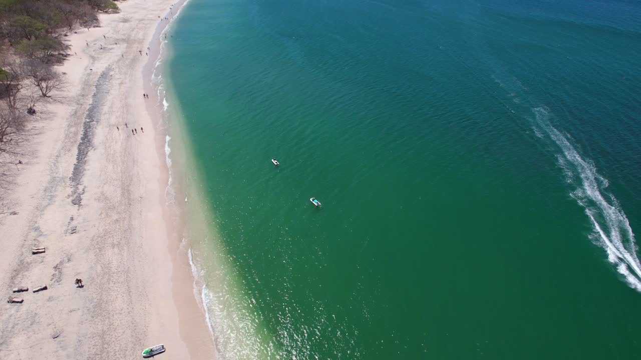 drone aéreo sobrevuela la playa de conchal costa rica con un barco en el océano azul, 4k