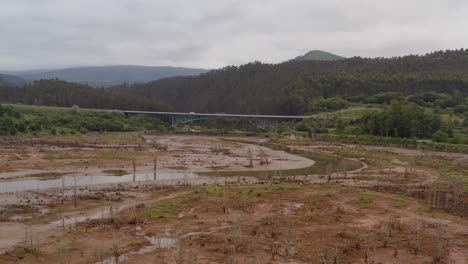 Verdant-nature-scene-of-Cantabria-landscape,-restored-wetland-in-foreground,-Autovía-del-Cantábrico-in-the-background