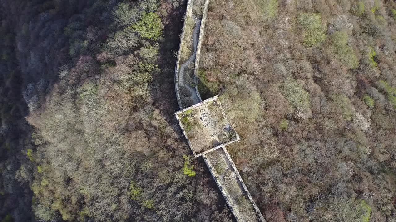 Spinning aerial looks down onto Great Wall of China remote watchtower