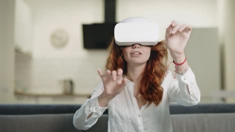 hermosa dama jugando interactivo en gafas virtuales en la cocina moderna.