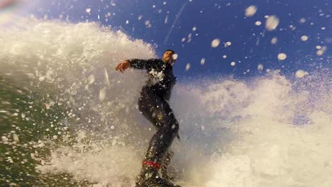 a surfer takes off and performs a sweeping roundhouse cutback on a wave at cascais beach in slow motion