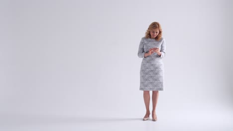 smiling mature woman using smartphone