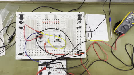 Espacio-De-Trabajo-De-Ingeniería-Electrónica-Con-Protoboard,-Cables-Y-Multímetro