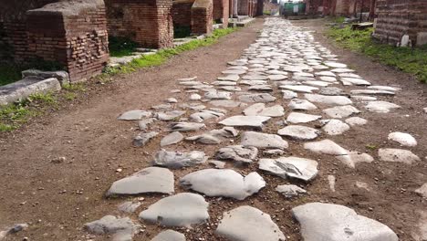 Roman-road-stone-paved-separating-insulae-in-the-huge-and-world-famous-archaeological-site-of-Ostia-antica-in-the-outskirts-of-Rome