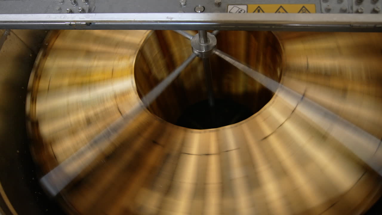 Quick spinning of honey frames in the automatic machine. Wooden honey frames are rotated to remove fresh organic honey from them.