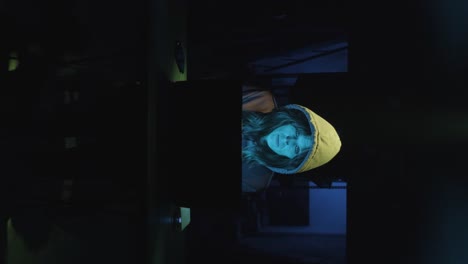 vertical shot of a female hacker working in a modern workspace late at night.