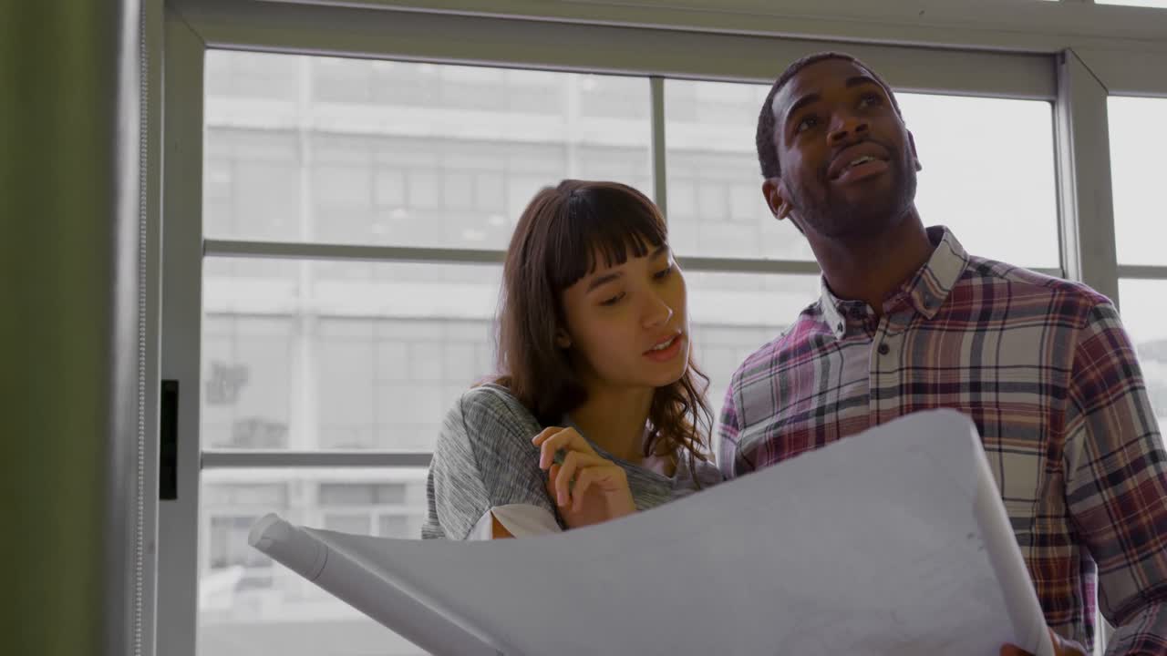 Business people working together on blueprint in a modern office 4k