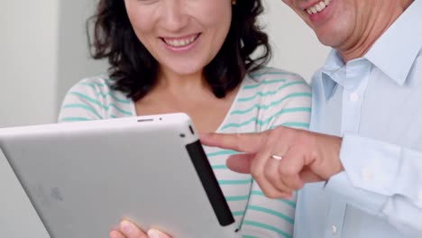pareja sonriente usando una tableta digital
