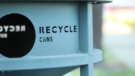 recycle cans sign imprinted into trash can tracking right close up