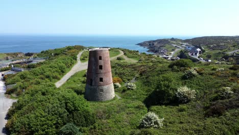 puerto amlwch ladrillo rojo en desuso abandonado molino de viento de madera vista aérea norte de anglesey gales aumento lento derecho