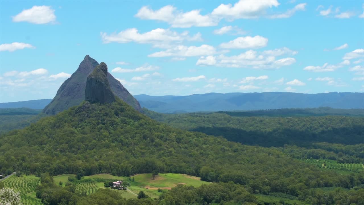 Beautiful picturesque view across the Glasshouse Mountains towards Mt Coonowrin and Mt Beerwah, from the summit of Mount Ngungun on a warm, clear summer day, with rainforests shrouding the mountains