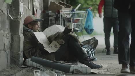 a man begging on the street, illustrating homelessness and poverty