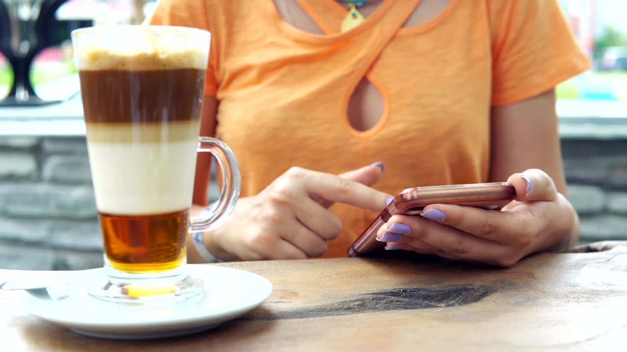cerrar las manos usando teléfonos inteligentes dispositivo de pantalla táctil digital mientras bebe café