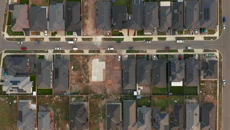 Smooth-aerial-perspective-looking-directly-down-on-Australian-suburban-housing-development-with-concrete-slab-freshly-laid-on-new-block